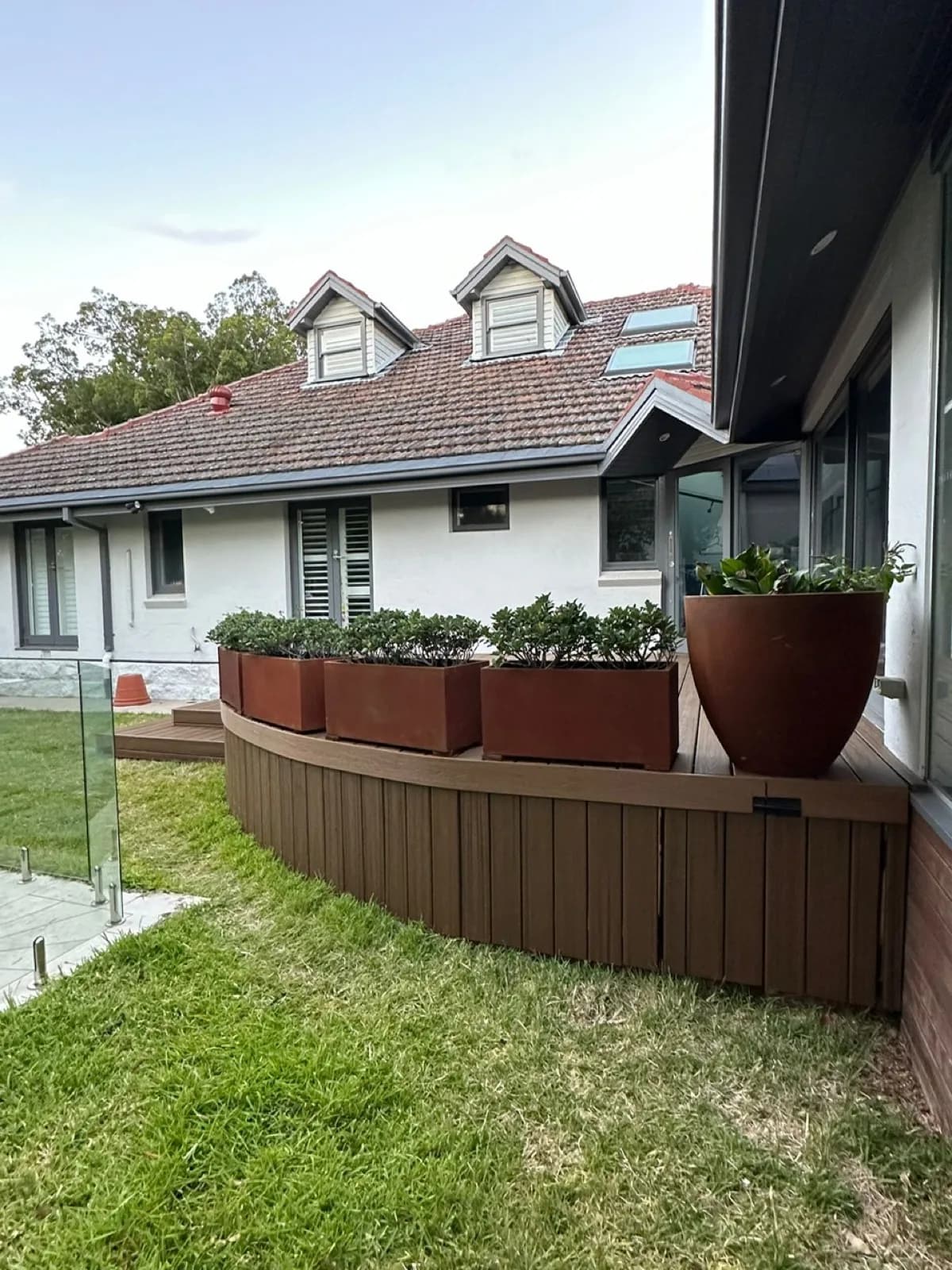 Curved slatted fascia under planter boxes, close view
