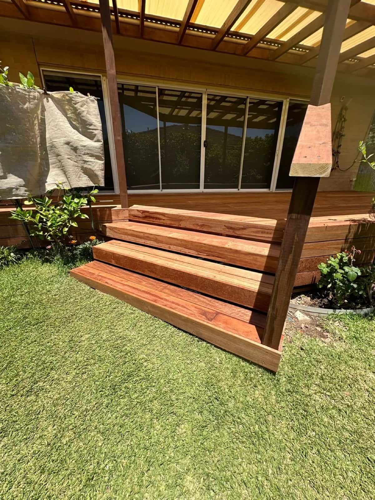 Merbau steps from lawn up to deck under timber pergola