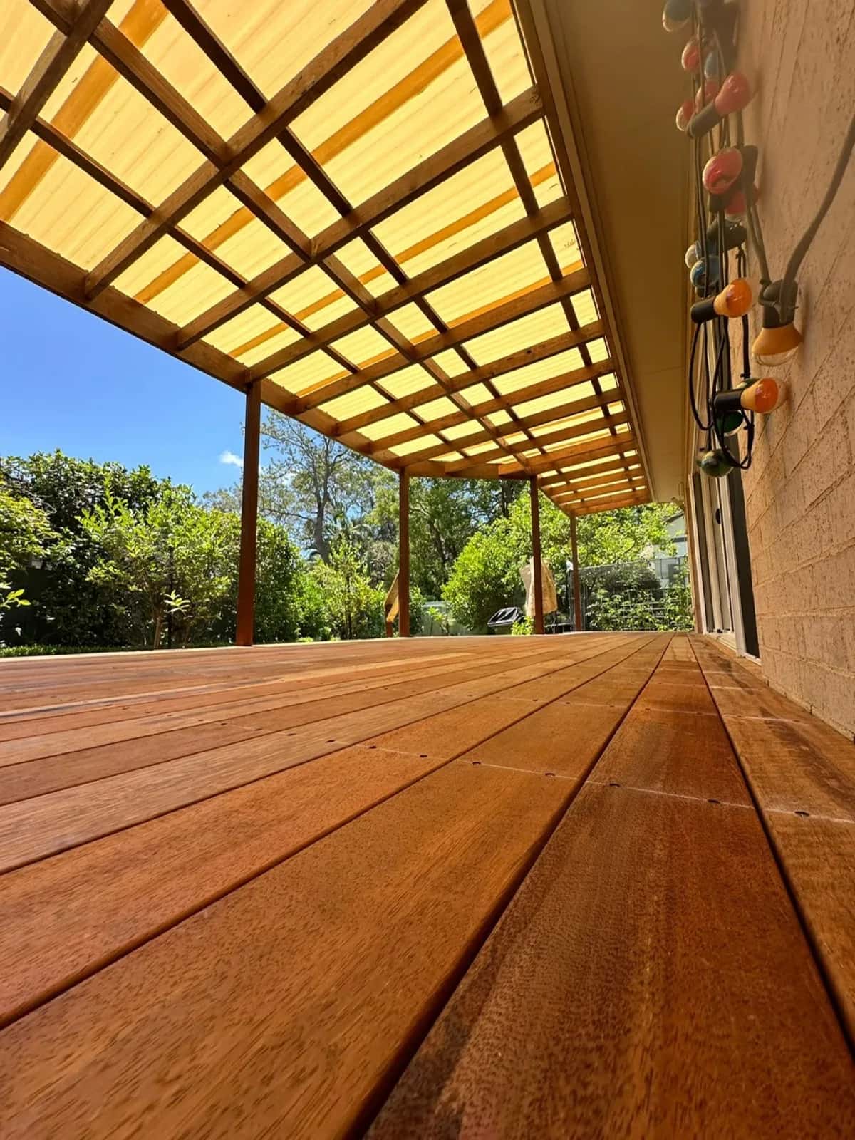 Low angle under pergola showing rafters and roof sheets