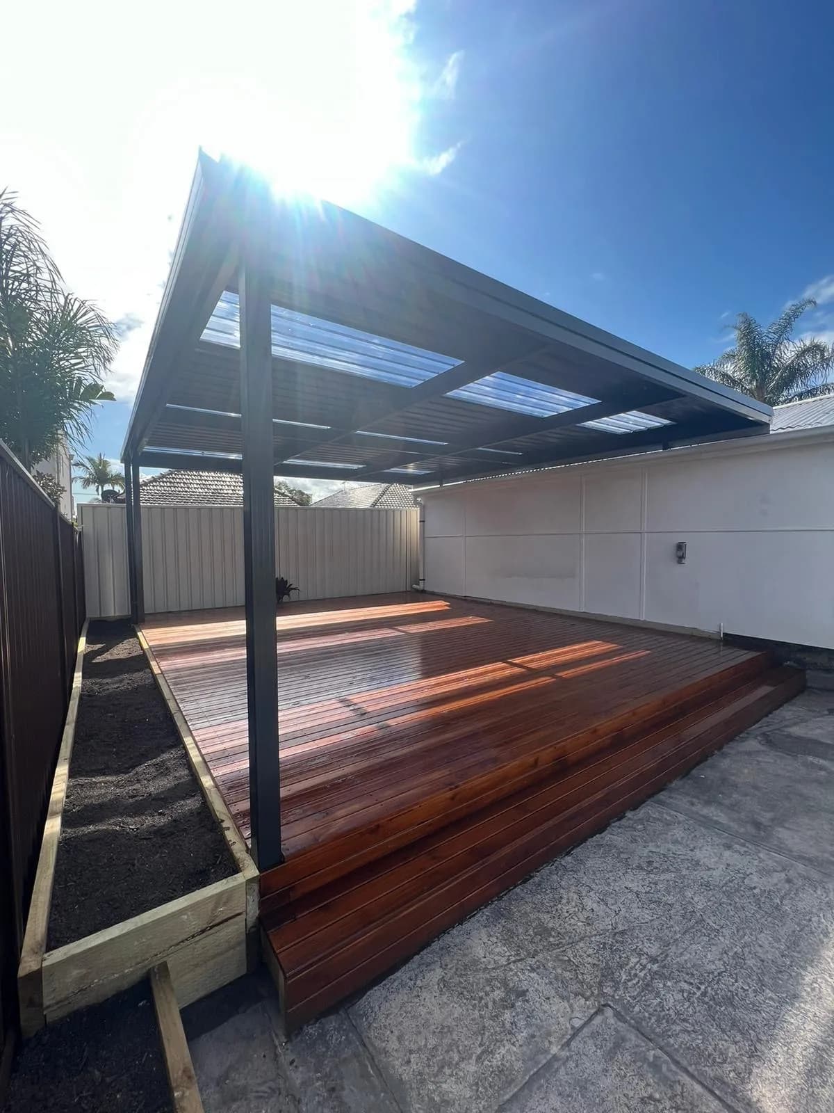 Stained deck with sun flare and timber garden-bed edging