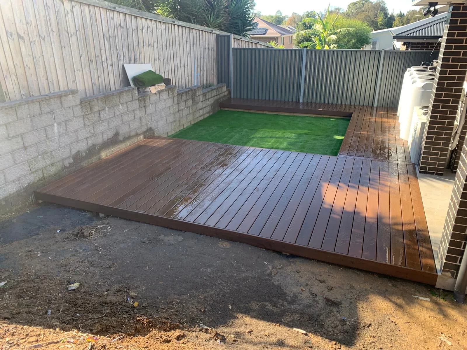 Deck along block retaining wall with turf