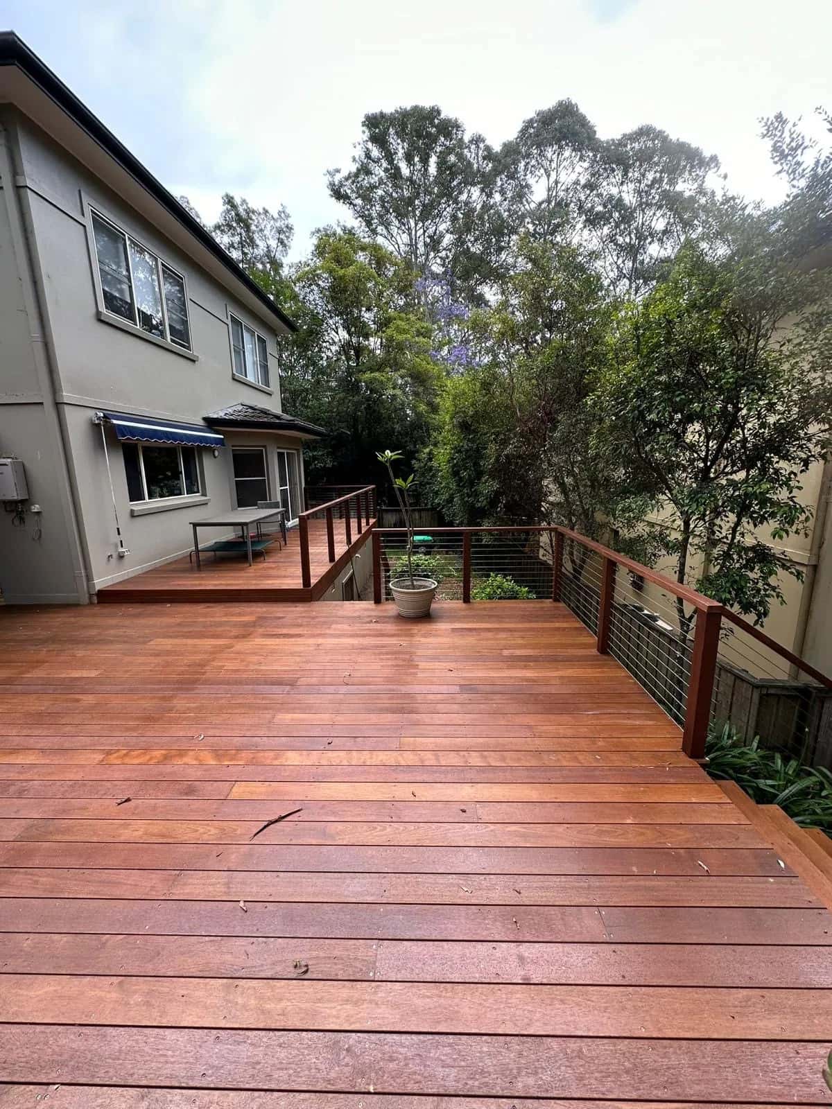Merbau deck towards two-storey house, wire balustrade